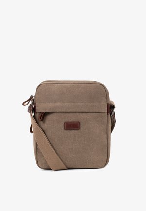 Sac bandoulière en toile marron avec poche zippée à l'avant, sangle ajustable et petite pièce rectangulaire en cuir avec logo centrée devant.