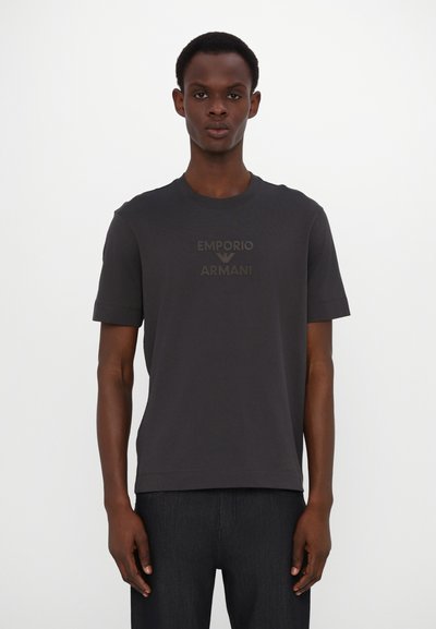 Tricou scurt cu maneci, de culoare gri închis, fabricat din bumbac, având un logo subtil împ embossat "EMPORIO ARMANI" pe față. Gat clasic de tip crew.