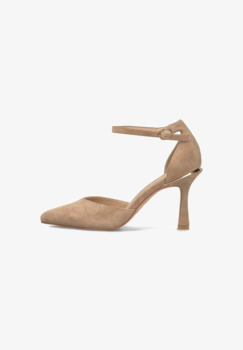 Zapato de tacón alto de ante beige con punta afilada, correa en el tobillo asegurada por una hebilla de metal redonda y un tacón slim de aguja.