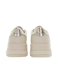 Bílé tenisky s hladkým koženým svrškem. Kovové stříbrné akcenty na patě. Tlustá, strukturovaná podrážka pro polstrování. Zaoblený tvar špičky.