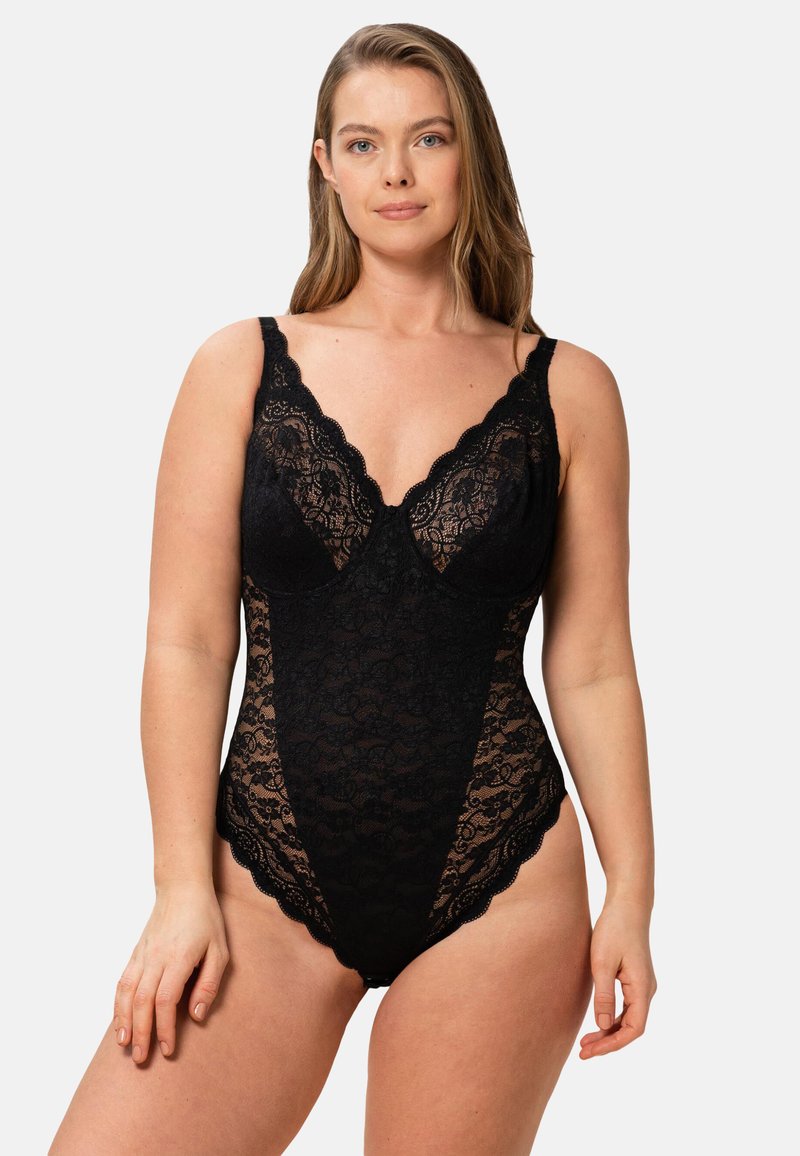 Svart spetstrosor med scallopade kanter, djup halsringning och justerbara remmar. Genomskinliga lakdetaljer på sidorna ger textur.