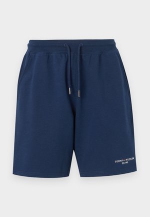 Shorts décontractés bleu marine avec taille à cordon et poches latérales, avec petit logo Tommy Hilfiger blanc et rouge sur la cuisse gauche.
