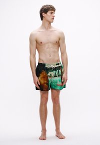 Herren-Badeshorts mit lebendigem Druckdesign, einer Collage aus Bildern, einem Kordelzug in der Taille und einfarbigen schwarzen Akzenten.