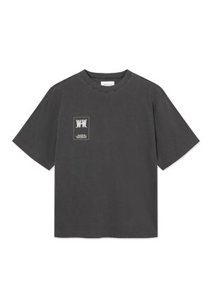 Krótki rękaw, T-shirt w kolorze grafitowym z okrągłym dekoltem oraz małym białym graficznym logo tekstowym na lewej piersi.