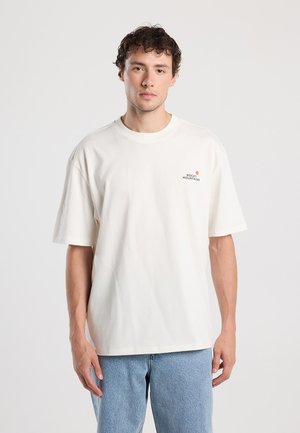 Cream-colored, short-sleeved t-shirt made of cotton, featuring a small logo on the chest. Loose fit with a round neckline.