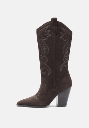 Botte de cowboy en daim marron avec bout pointu, couture décorative et talon bloc. Comprend une tige haute et une languette pour un enfilage facile.