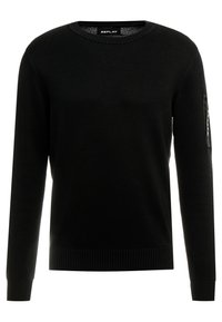 Pull en tricot noir avec un col rond, des manches longues, des poignets et un ourlet côtelés, doté d'une poche zippée sur la manche gauche.