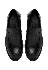 Mocassins en cuir noir avec une finition lisse, dotés d'une large bride sur le devant et de subtils détails de coutures le long des bords.
