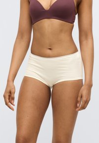 Κρεμ υφασμάτινο εσώρουχο hipster με δαντέλα στη μέση, σχεδιασμένο για άνεση και πλήρη κάλυψη, αναδεικνύοντας ομαλή υφή και εφαρμογή.