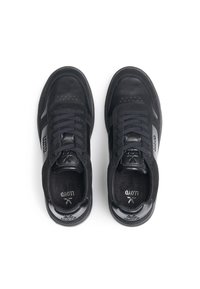 Sneakers neri con corpo in pelle liscia, dettagli in suede, perforazioni sulla punta e lacci piatti. Collo imbottito per il comfort.