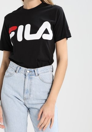 Czarna koszulka z dużym białym i czerwonym logo "FILA", połączona z jasnoniebieskimi dżinsami o wysokim stanie. Klasyczny design z okrągłym dekoltem.