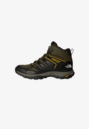 Mid-cut hiking boots in olive green with black accents, featuring a mesh upper, Vibram sole, and prominent lacing system. Yellow design details.