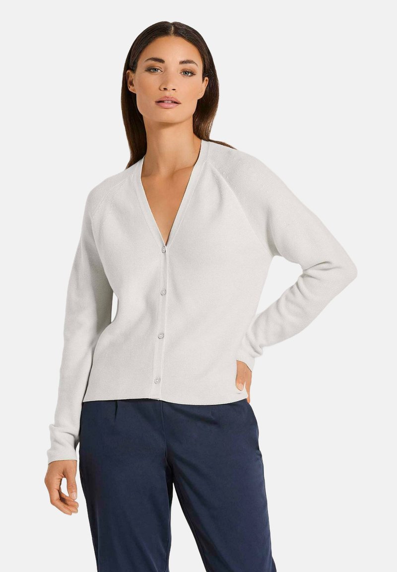 Witte cardigan met een V-hals, een knoopsluiting aan de voorkant en raglanmouwen. Zachte textuur en een getailleerd ontwerp, aangevuld met een subtiele ribbelafwerking.