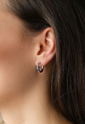 Sølv hoops ørering med en flerfarvet stenaccent, vist på en models øre, der fremhæver sin cirkulære form og polerede finish.