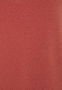 Tissu rouge texturé avec une surface lisse et un motif de tricot fin, affichant une couleur uniforme et une apparence douce. Aucun motif ou accent distinct.