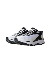 Paire de baskets athlétiques noires et blanches avec semelles épaisses et panneaux en mesh, montrée inclinée vers la droite sur fond blanc.