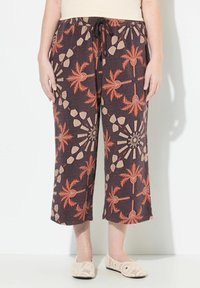 Bruna korta byxor med palm- och geometriska mönster i orange och beige. Tillverkade av ett texturerat tyg, med elastisk midja och snörning.