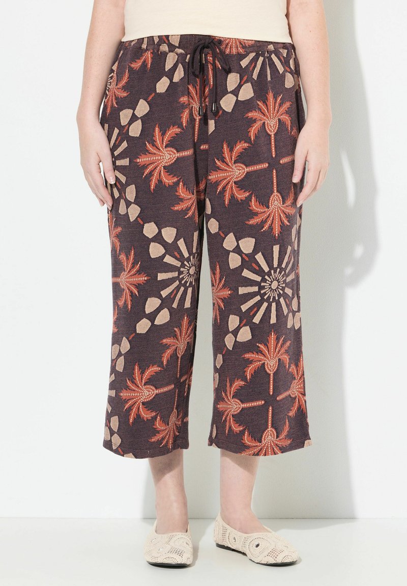 Bruna korta byxor med palm- och geometriska mönster i orange och beige. Tillverkade av ett texturerat tyg, med elastisk midja och snörning.