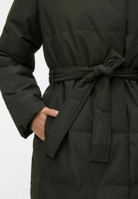 Zaļš polsterēts mētelis ar jostu viduklī, sānu kabatu un mīkstu, teksturētu audumu ar horizontālu rievotu rakstu.