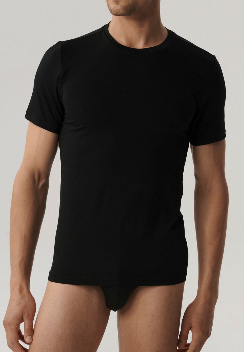 Czarny krótki rękaw t-shirt wykonany z gładkiego materiału, z okrągłym dekoltem i dopasowanym krojem, który podkreśla sylwetkę.