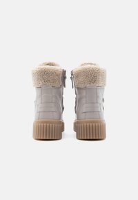 Halli nahast pahkluu saapad kunstkarvase voodri, tekstureeritud kummist taldse ja külje peal oleva luku sulgemisega. Kontsal on brändi märgistus.