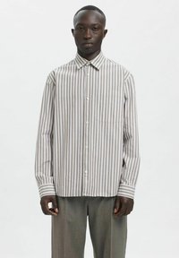 Stripete skjorte med knapper i lys beige og mørk brun med krage, enkelt brystlomme og lange ermer. Glatt stoff med avslappet passform.