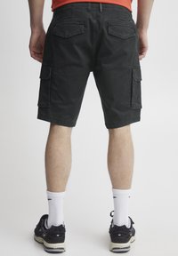 Svarte cargo shorts med avslappet passform, med sidelommer og baklommer med klaff, laget av lett stoff med en glatt tekstur.