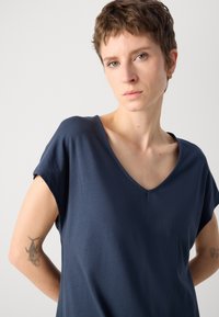 Navy blue V-neck t-shirt with short sleeves, soft fabric, relaxed fit; visible stitching detail and smooth texture.