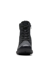 Front view of black lace-up ankle boot with thick sole, zipper on side, and padded collar.