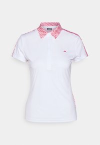 Bílá polo košile s vzorovaným růžovým límečkem a akcenty na rukávech. Obsahuje knoflíkovou légu a malé logo na hrudi.