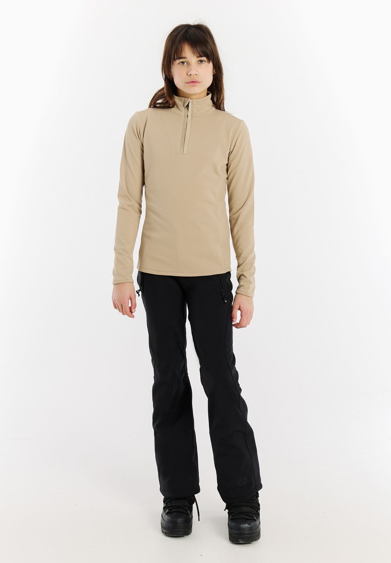 Bežová dlhá rukávová blúzka s polovičným zipsom a čiernymi lyžiarskymi nohavicami. Hladký povrch, priliehavý strih, vhodné na vonkajšie aktivity.