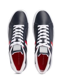 Sneakers in pelle blu con lacci bianchi, strisce rosse e bianche sui lati e un interno rosso. Presenta un logo sulla linguetta. Suola bianca piatta.