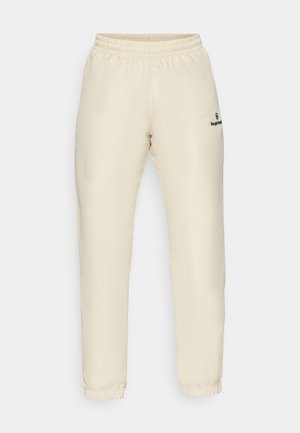 Pantaloni da jogging beige con vita elastica e una trama liscia. Presentano polsini arricciati e un piccolo logo nero sul lato sinistro.