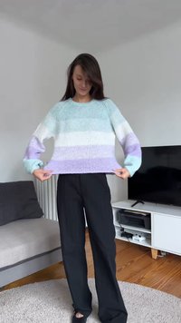 Pull-over tricoté en dégradé de bleu clair, blanc et lavande. Doté d'un col rond et de manches longues légèrement surdimensionnées.