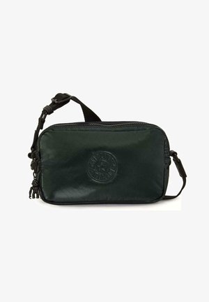 Petit sac noir porté en bandoulière avec sangle réglable, logo circulaire embossé sur le devant, et petit porte-clés attaché à la fermeture éclair.