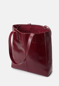 Bordo usnjeni tote bag z gladko teksturo, dvema trdnima naramnima trakoma in zgornjim zadrgo. Notranjost ima ujemajočo se tekstilno podlogo.
