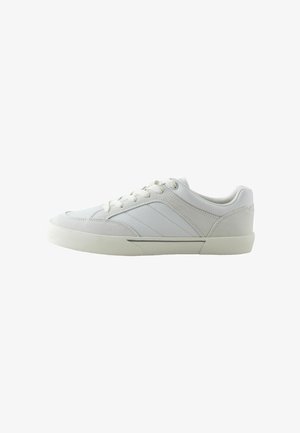 Witte low-top sneaker met veters, rubberen zool en subtiele gestikte paneeldetails aan de zijkant, getoond in rechter profiel.