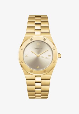 Reloj de pulsera de metal con acabado en tono dorado, con esfera redonda, marcadores de números romanos en las posiciones 12, 3, 6 y 9, y una correa de eslabones.
