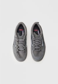 Een paar grijze veterschoenen met gestructureerde stof en suede details, van bovenaf bekeken op een witte achtergrond.