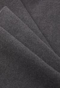 Tissu gris foncé avec une texture lisse et douce, présentant un motif subtil. Plusieurs couches superposées mettent en valeur son épaisseur et ses plis.