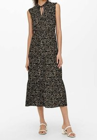 Svart och beige leopardmönstrad klänning med krage, nyckelhålsöppning och ärmlös design; flödande midilängd med insvängd midja.