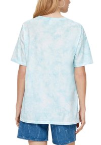 Lichtblauwe tie-dye t-shirt met een relaxte pasvorm en korte mouwen. Gemaakt van zachte stof, met een ronde halslijn en subtiele textuur.