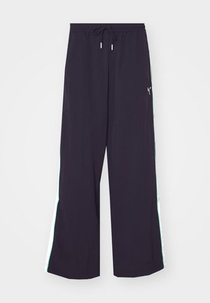 Pantalons larges noirs en tissu léger. Dotés d'une taille élastique avec cordon de serrage et de bandes latérales vertes contrastantes avec un accent logo.
