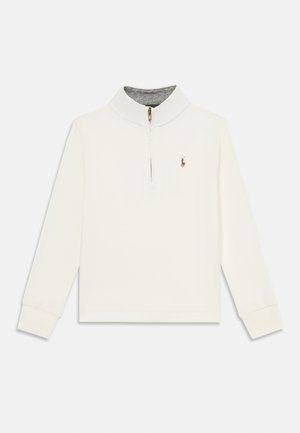 Pull-over blanc à manches longues avec un col à demi-zip, doublure intérieure grise et logo brodé sur la poitrine. Texture douce, coupe décontractée.
