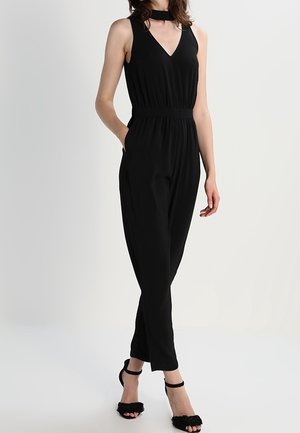Schwarzer Jumpsuit mit V-Ausschnitt und ärmellosem Design, ausgestattet mit einem gebundenen Choker-Ausschnitt, elastischem Taillenbund und seitlichen Taschen.