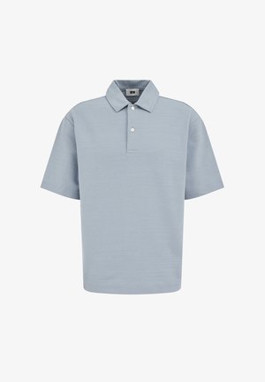 Šviesiai mėlyna trumpomis rankovėmis polo marškinėliai su tekstūruota medžiaga, išskleistu apykakliu ir dviem baltais mygtukais priekyje.