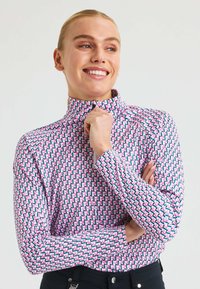 Pitkähihainen korkea kaula -paita, jossa on geometrinen kuvio vaaleanpunaisesta, sinisestä ja valkoisesta. Valmistettu joustavasta kankaasta, jossa on istuva siluetti.