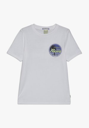 Biała koszulka z krótkim rękawem, okrągłym dekoltem i małą okrągłą naszywką na lewej piersi z motywem palmy i napisem "Sunshade Resort".