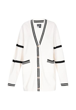 Valkoinen neuletakki, jossa mustat raidat hihoissa, hihansuut, etureunat, kaksi etutaskua ja viisi nappia keskellä.