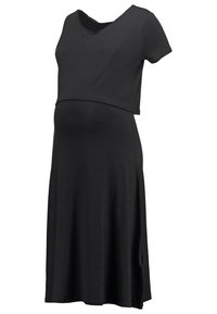 Robe de maternité noire avec manches courtes et un haut superposé sur une jupe fluide.